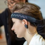Mulher usando uma faixa de EEG na cabeça em um ambiente interno.