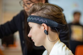 Mulher usando uma faixa de EEG na cabeça em um ambiente interno.
