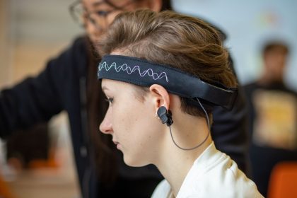 Mulher usando uma faixa de EEG na cabeça em um ambiente interno.