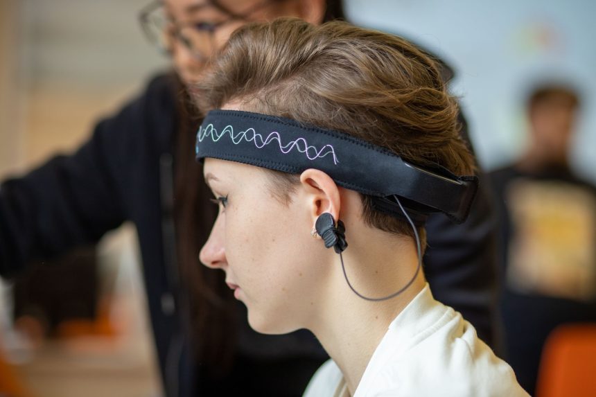Mulher usando uma faixa de EEG na cabeça em um ambiente interno.