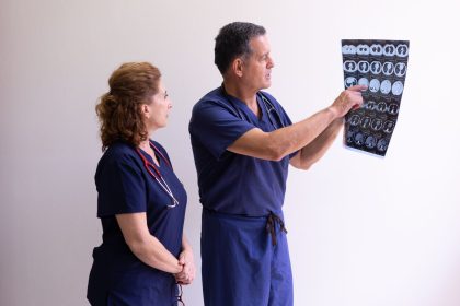 Dois profissionais de saúde examinam uma radiografia em um ambiente hospitalar.