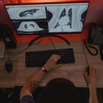 Radiologista analisa exames de raios X em vários monitores durante um procedimento de diagnóstico médico.